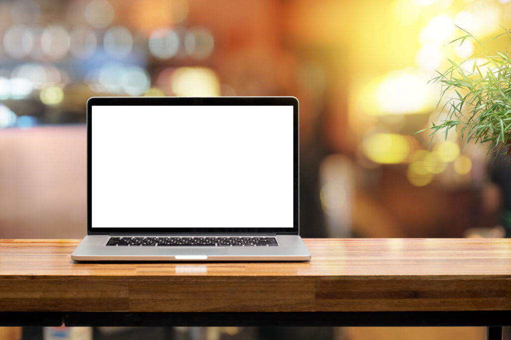 An open laptop on a table with a black screen.